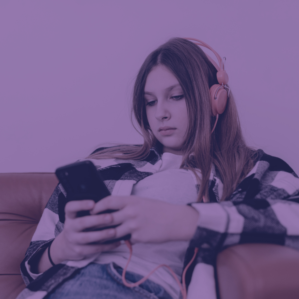 teenager wearing headphones using cellphone